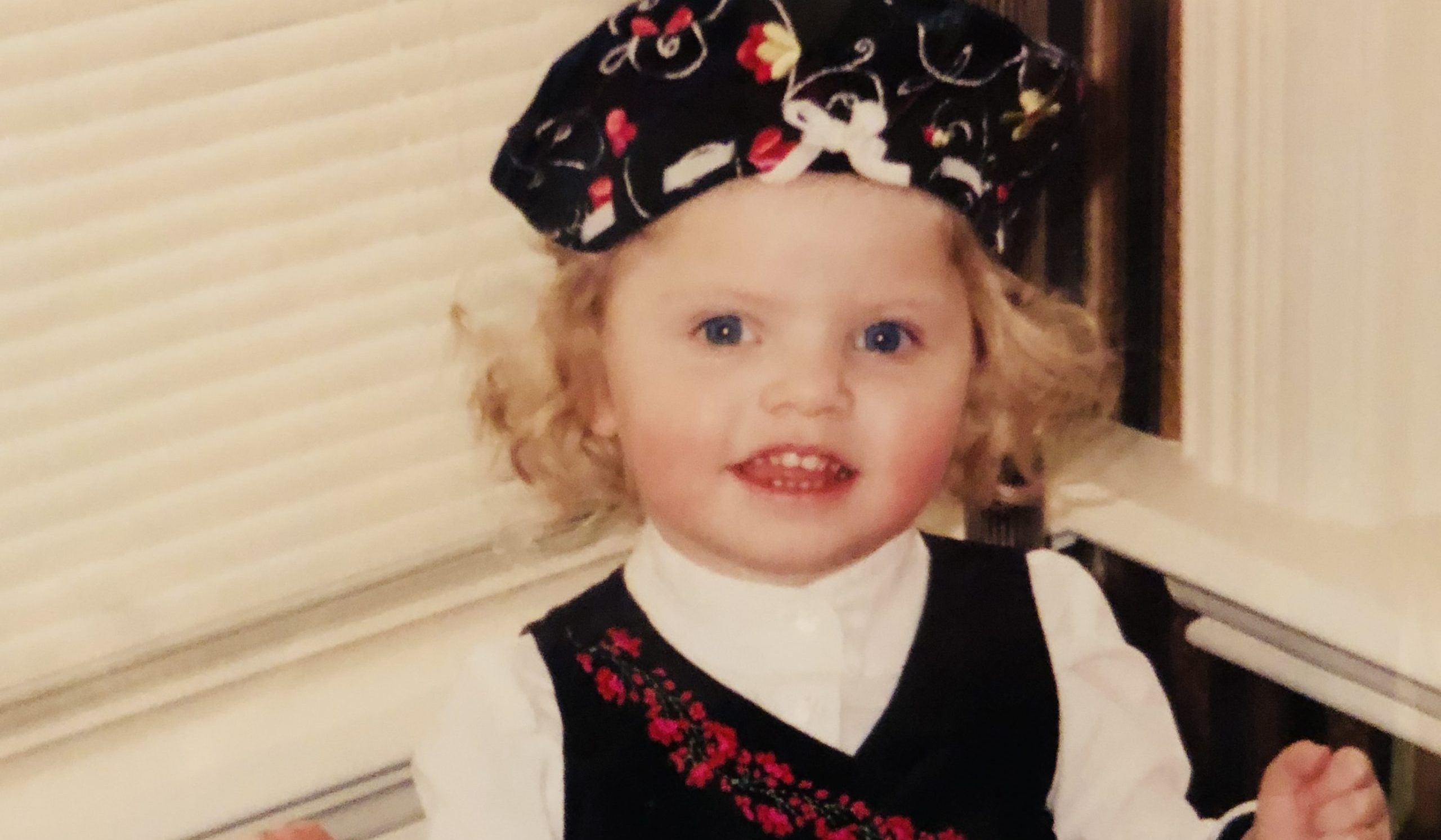 blonde toddler with christmas hat and outfit